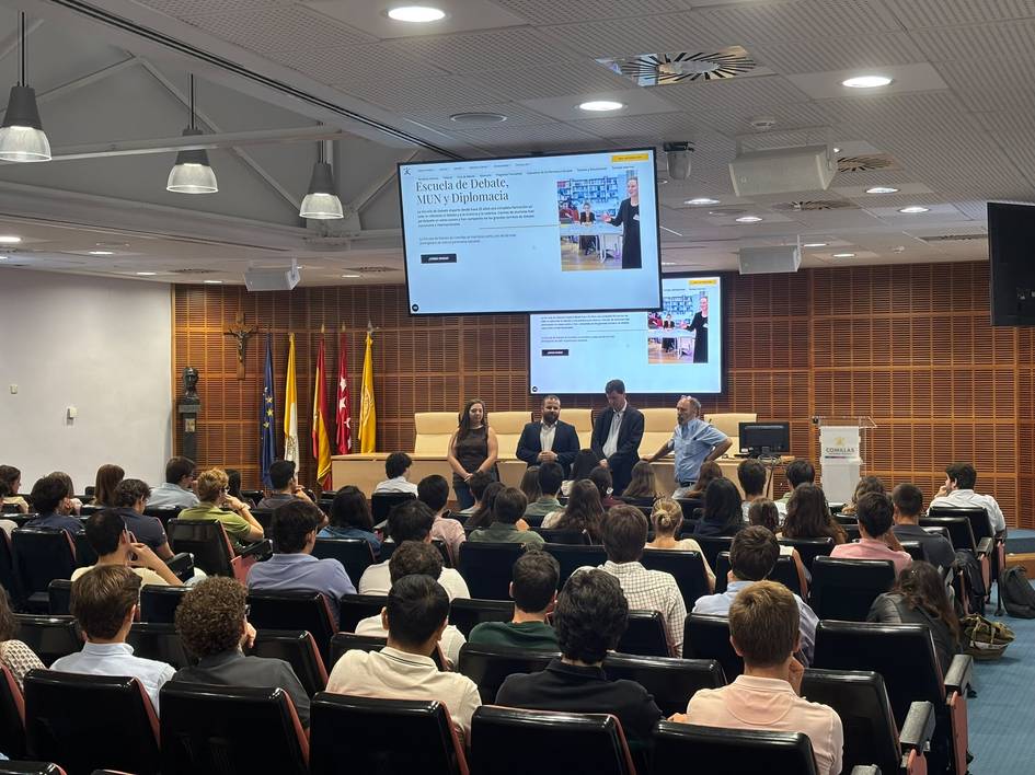 Una conferencia con varios ponentes frente a un público en un auditorio.
