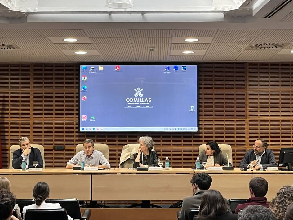 Five people sitting behind a desk in a panel discussion at Comillas University.