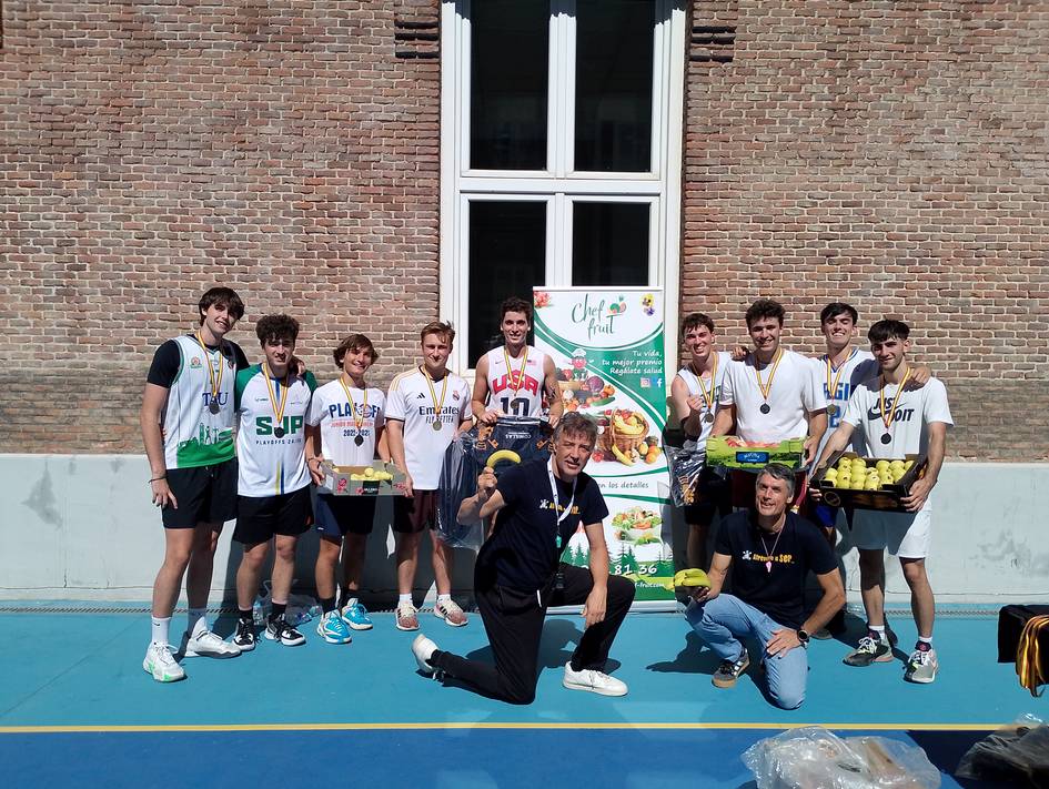 Grupo de jóvenes celebrando con medallas en una cancha de baloncesto.