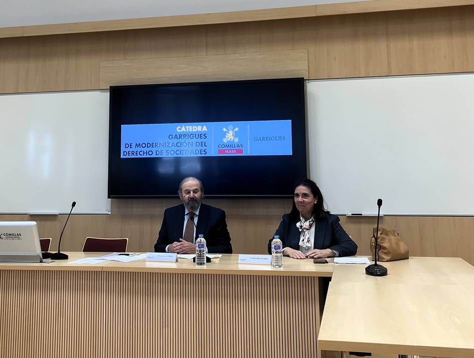 Un panel de conferencias sobre la modernización del derecho de sociedades con dos ponentes en una sala.