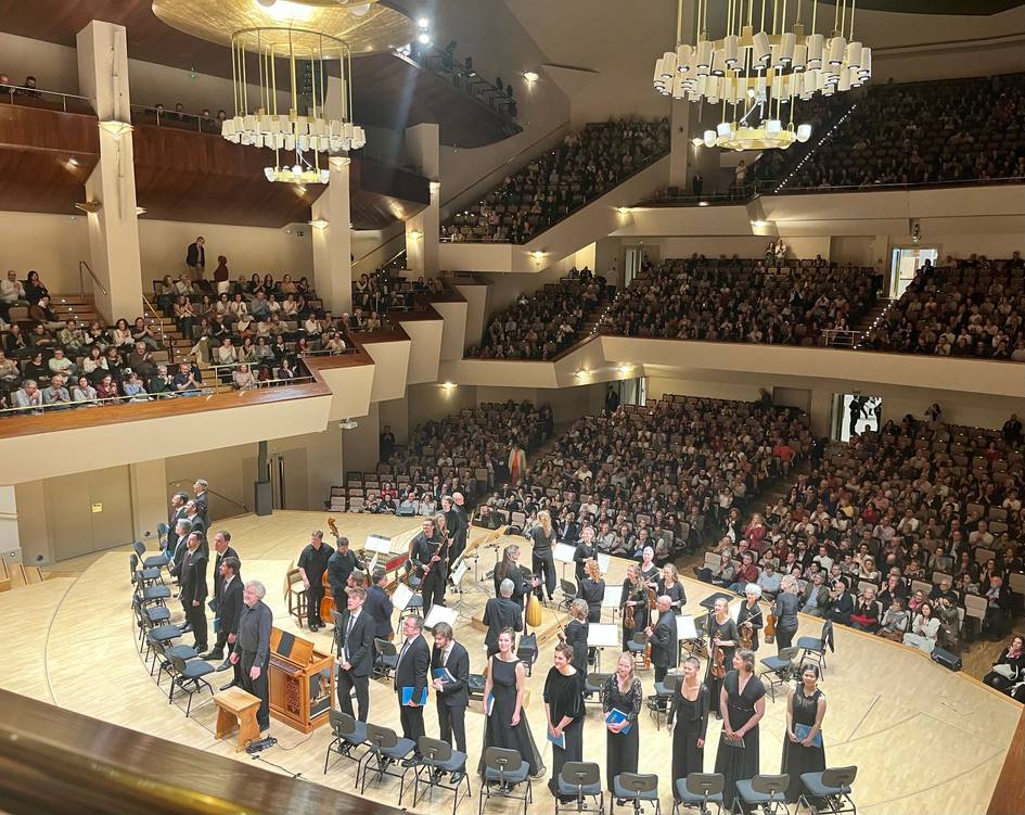 Un auditorio abarrotado durante un concierto con músicos en el escenario.