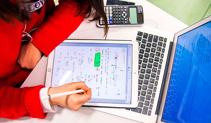 chica con tablet y ordenador estudiando matematicas