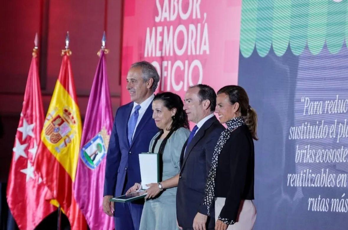 Un grupo de personas posando en un evento con banderas de fondo.