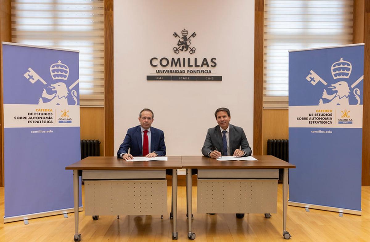 Dos personas firman un acuerdo en la Universidad Pontificia Comillas.