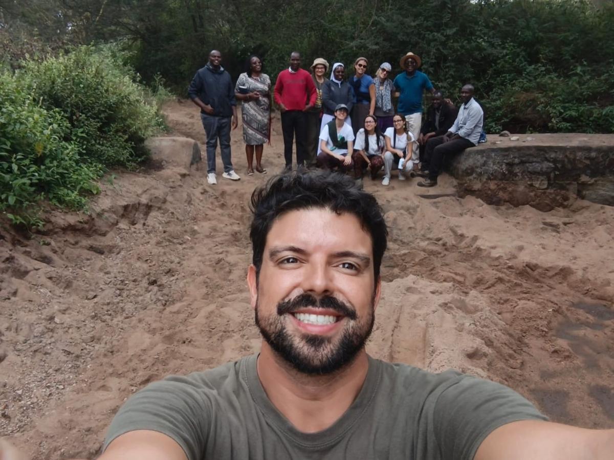 Un grupo de personas posando en un entorno natural mientras una persona toma una selfie al frente.