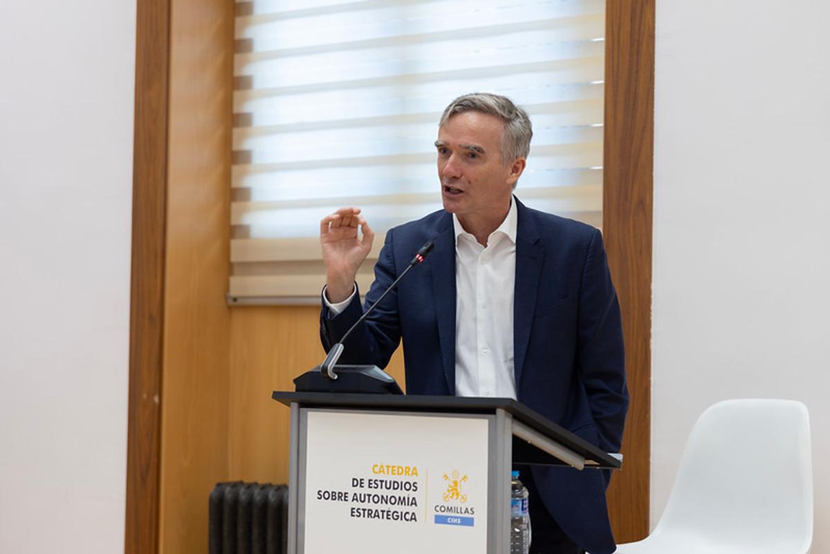 Un hombre está hablando en un podio durante un evento académico.