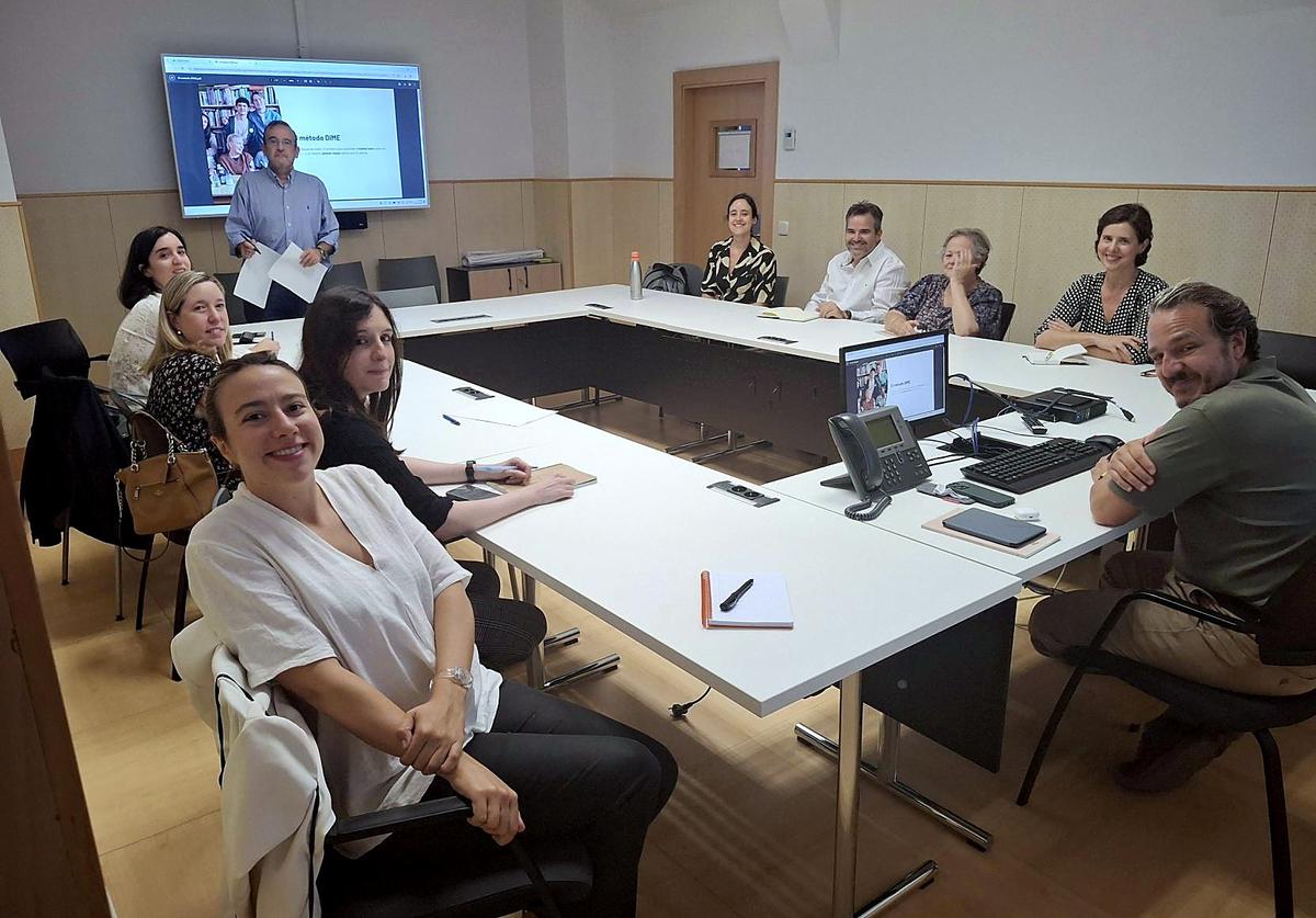 Un grupo de personas se encuentra en una sala de reuniones participando en una presentación.