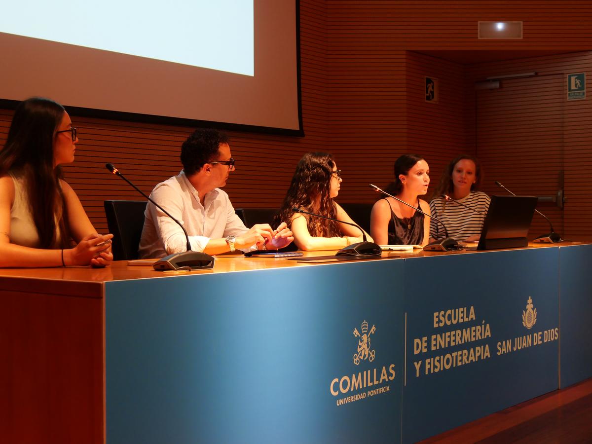 Un grupo de personas sentadas detrás de una mesa en un evento o presentación en la Escuela de Enfermería y Fisioterapia de Comillas.