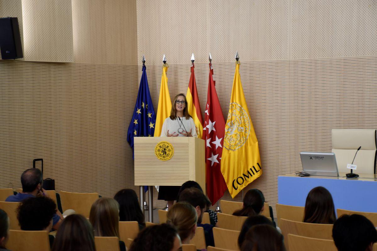Una mujer habla desde un podio ante un público en un evento oficial.