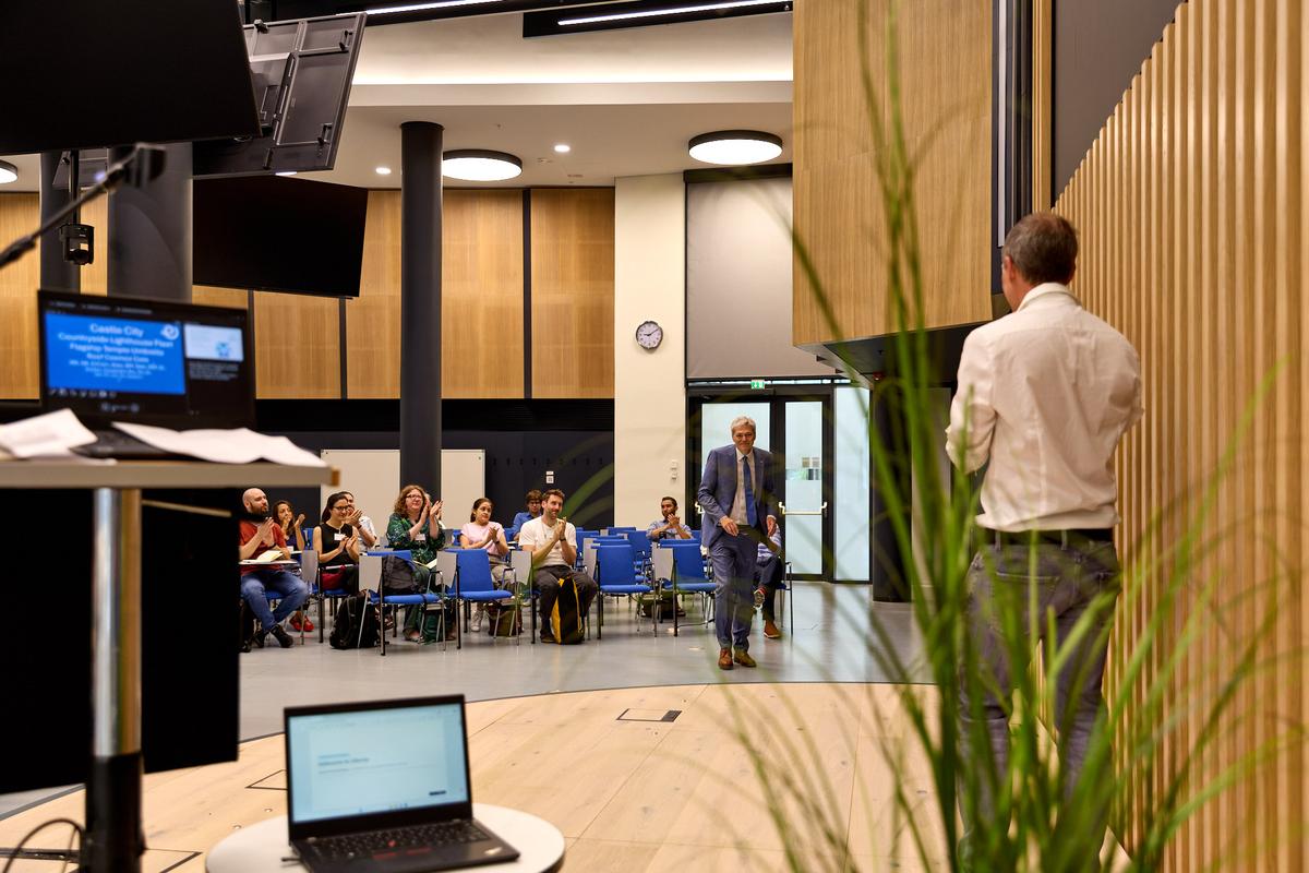 Un grupo de personas asiste a una presentación en un auditorio moderno.