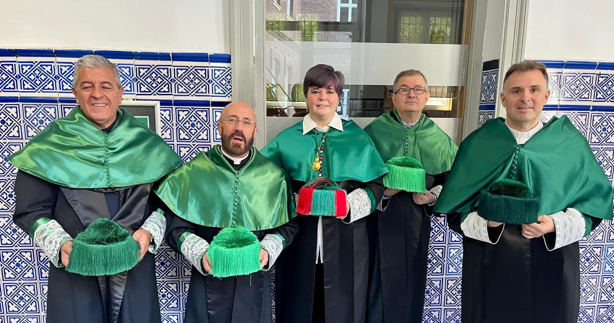 Un grupo de cinco personas vestidas con togas y capas verdes, posando frente a un fondo de azulejos.