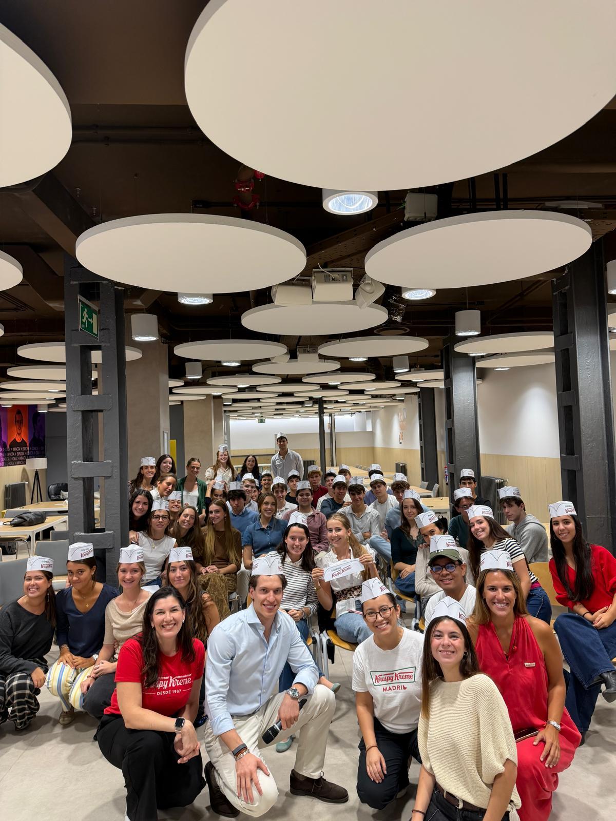 Un grupo grande de personas sonrientes posando en un ambiente iluminado y moderno.