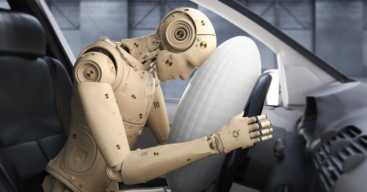 Un robot está simulando un choque al abrazar un airbag dentro de un automóvil.