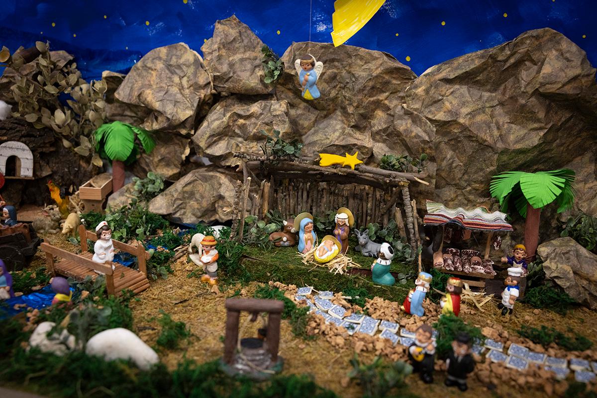 Una representación de un belén con figuras que recrean el nacimiento de Jesús en un paisaje natural.