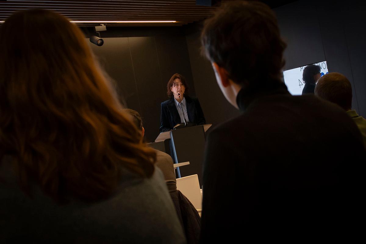 Un hombre da una presentación frente a una audiencia en una sala de conferencias.