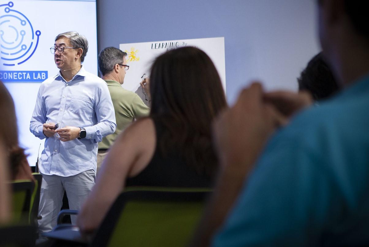 Un grupo de personas asiste a una presentación en un laboratorio de innovación.