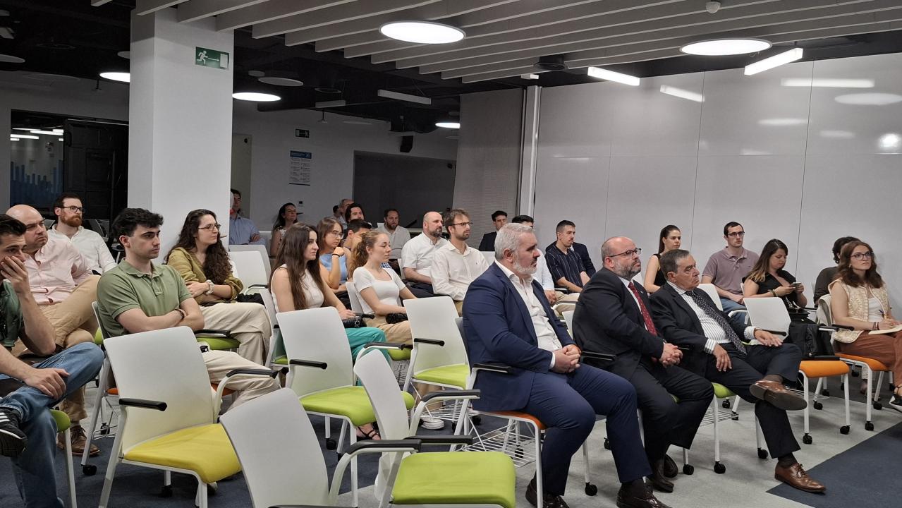 Una audiencia atenta durante una presentación en un espacio moderno.