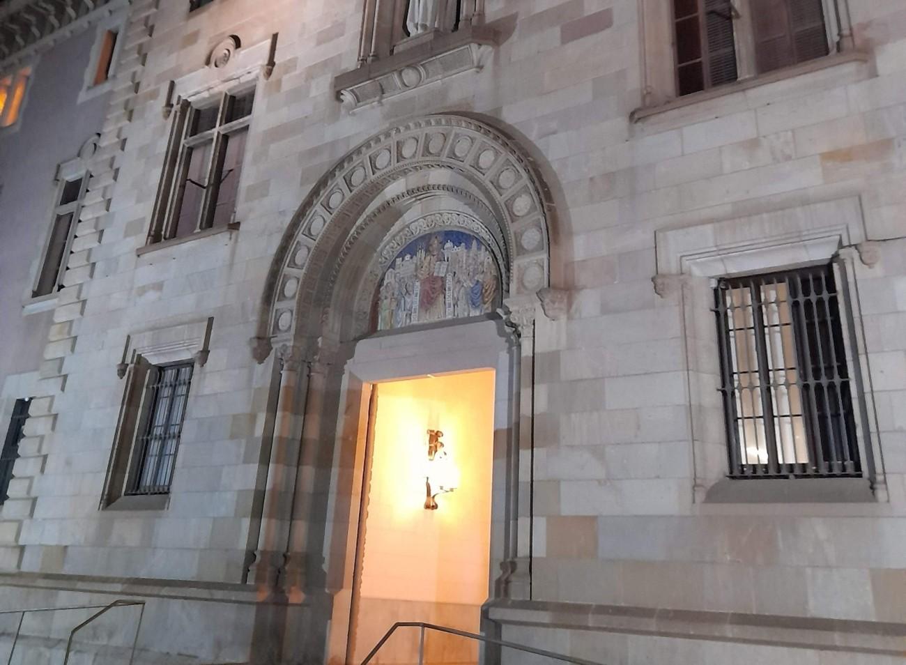 Una entrada de un edificio con detalles arquitectónicos y una iluminación suave.