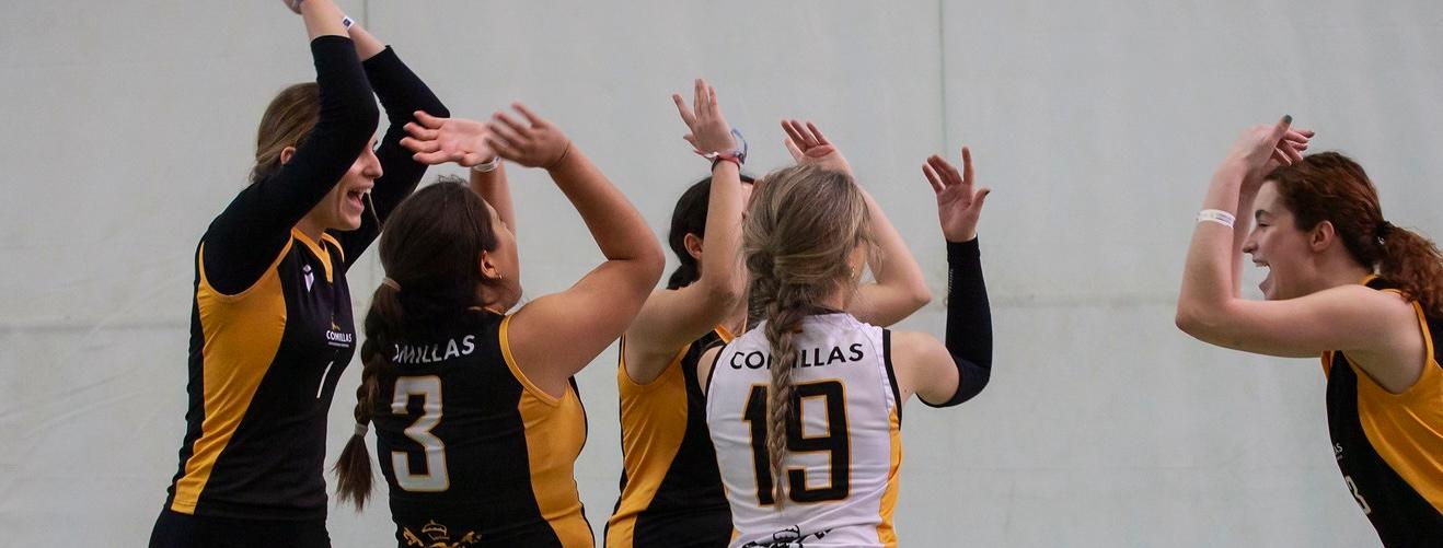 Un grupo de jugadoras de voleibol celebrando un punto durante un partido.