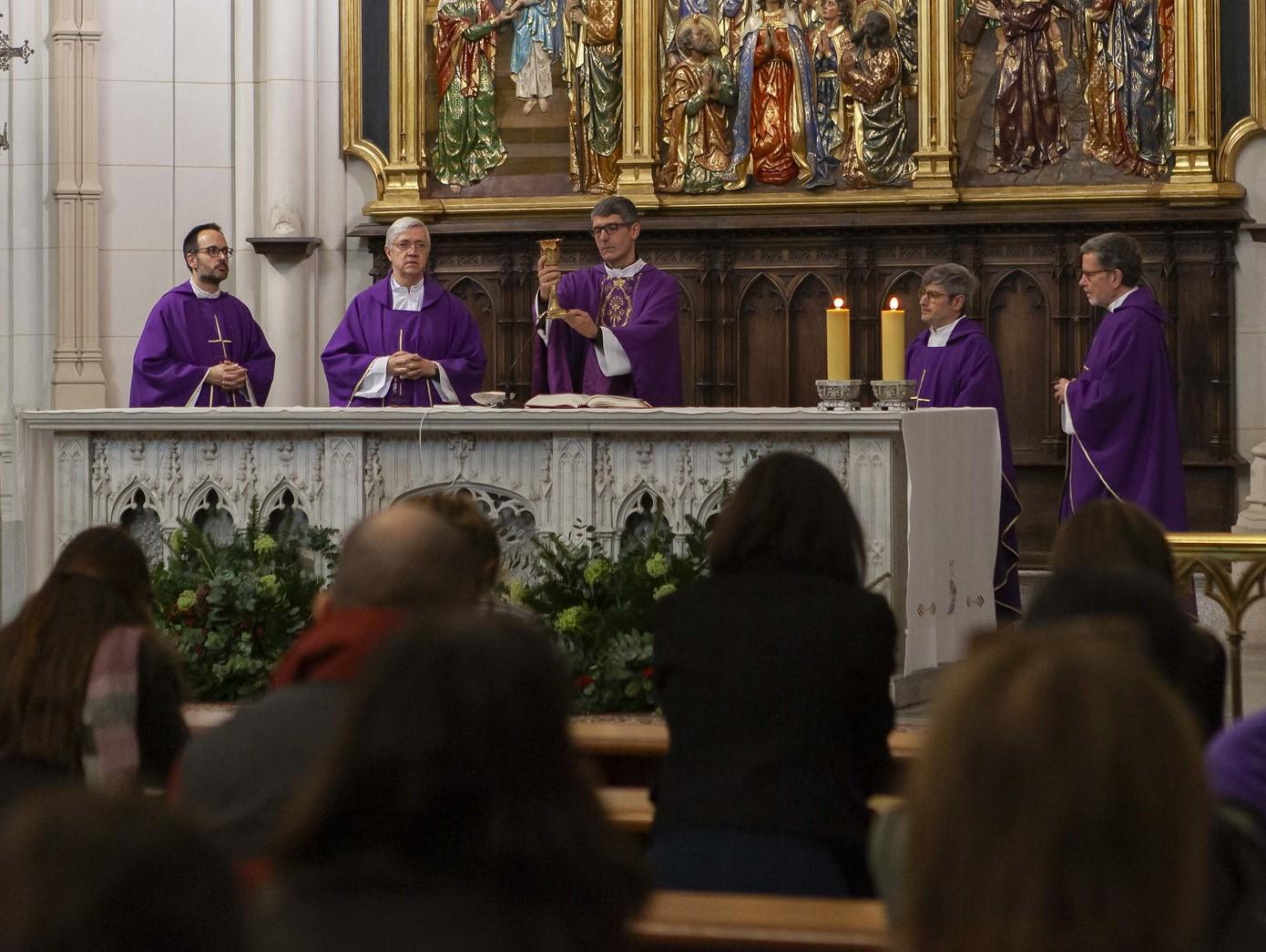 Sacerdotes vestidos con togas moradas oficiando una misa en una iglesia ante una congregación.