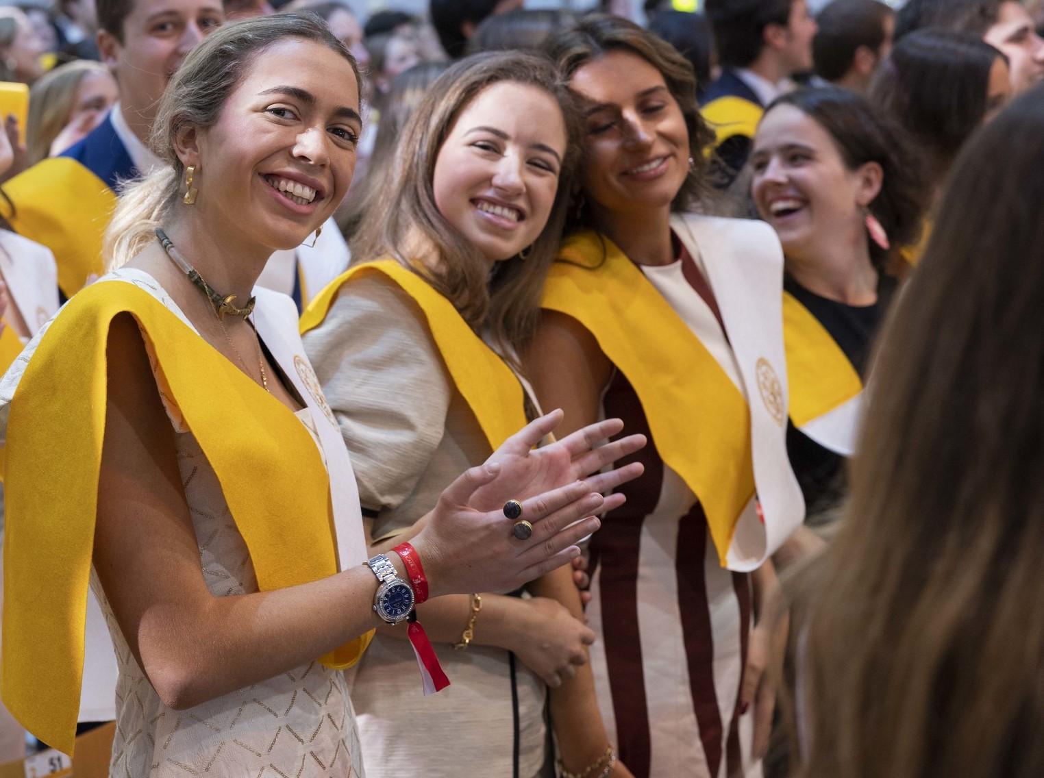 Un grupo de mujeres sonrientes en una celebración con togas y birretes.