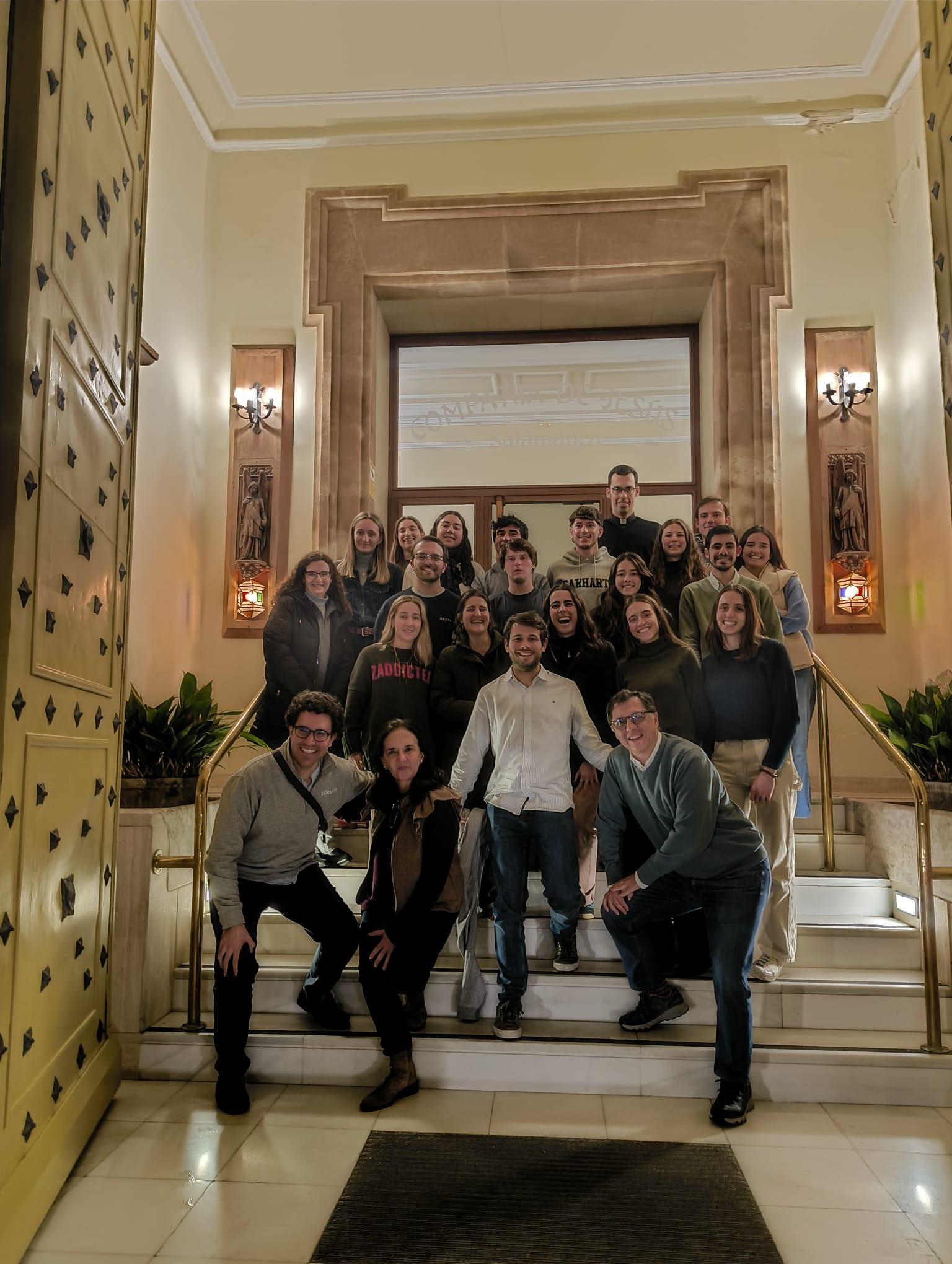 Un grupo de personas posando en una escalera en un edificio con decoración elegante.