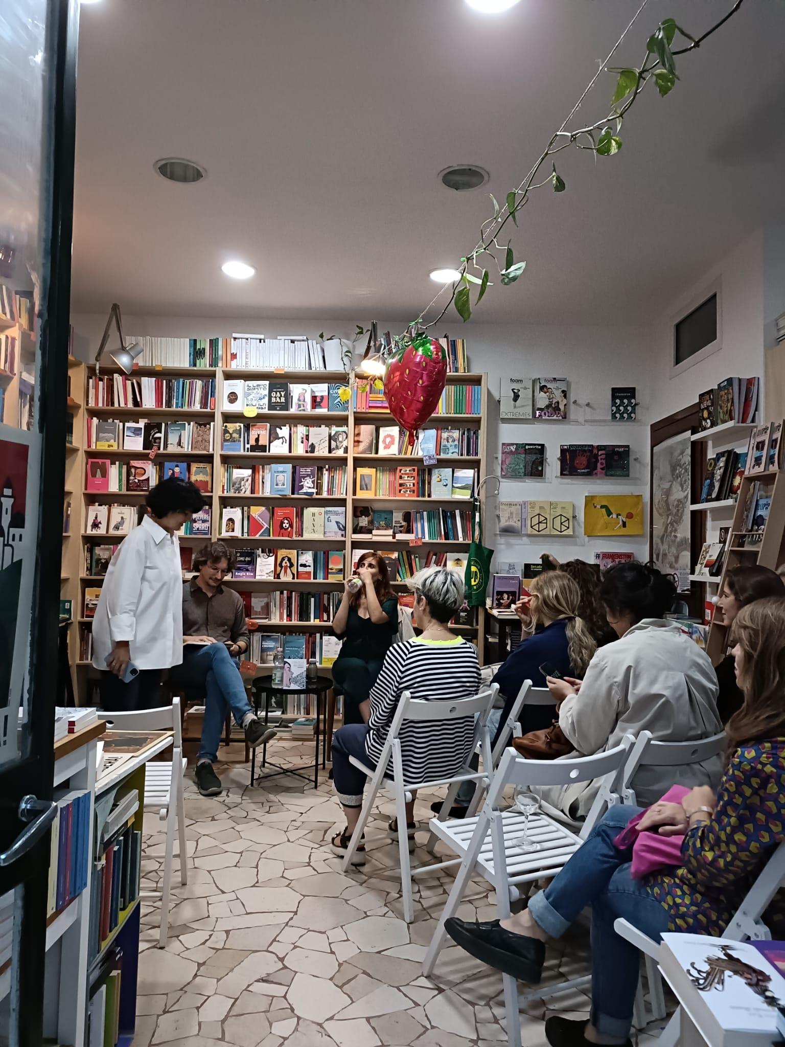 Un grupo de personas se encuentra en una librería durante un evento literario.