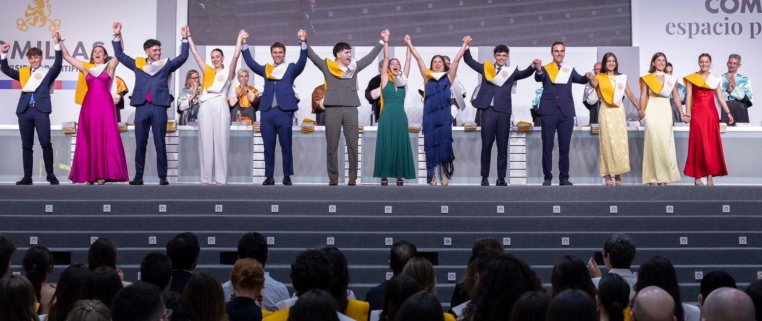 Grupo de graduados en una ceremonia levantando las manos en señal de celebración.