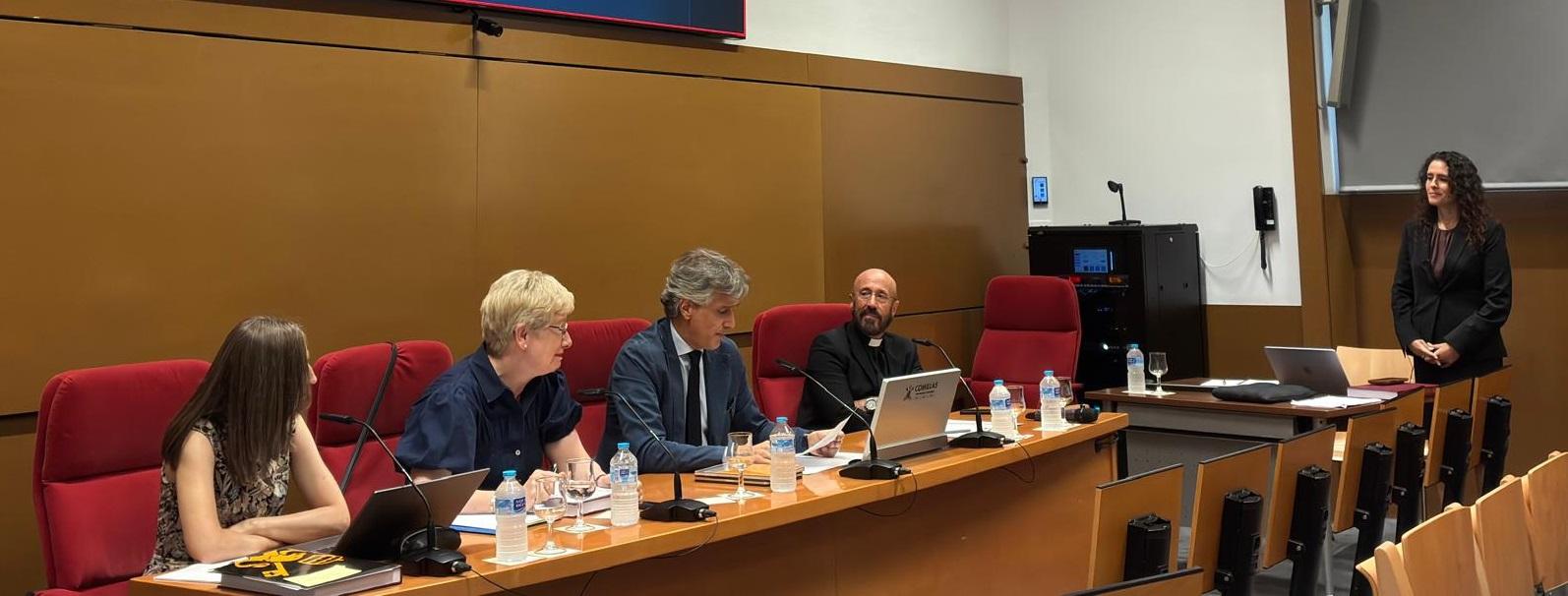 Un grupo de personas sentadas en una mesa durante un evento académico.