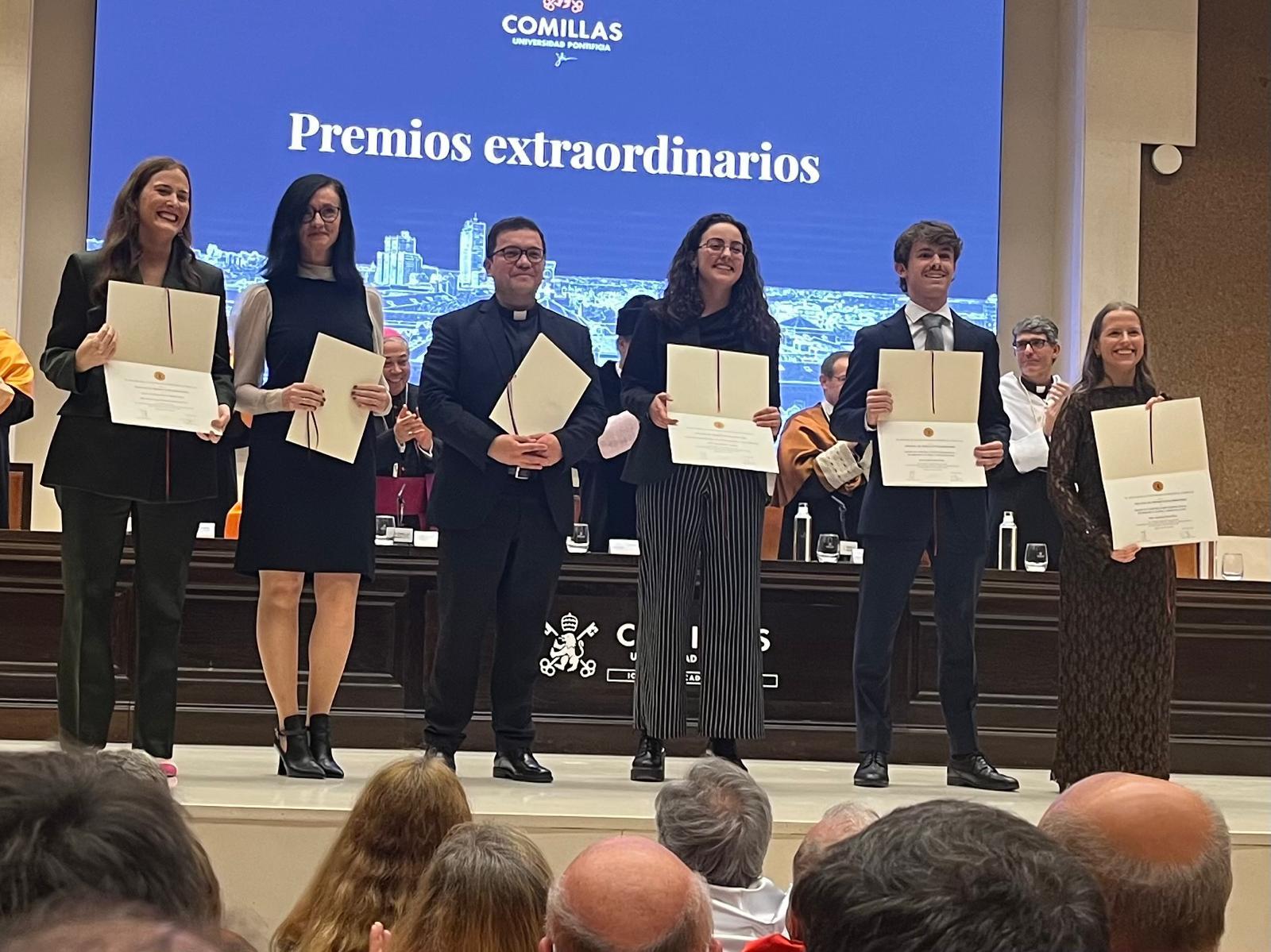 Un grupo de estudiantes sostiene sus diplomas en una ceremonia de premiación.