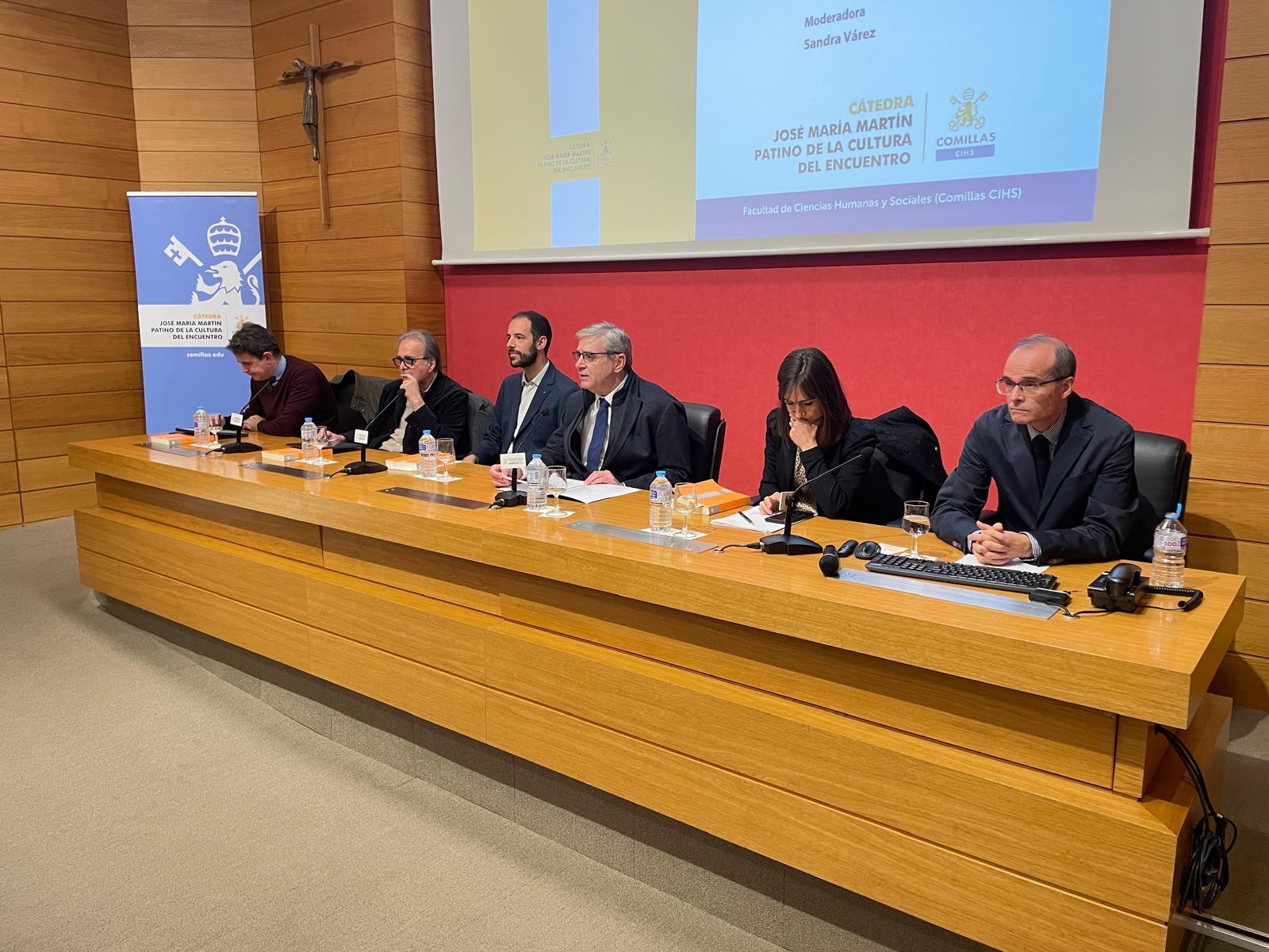 Una mesa redonda con varios ponentes discutiendo en un evento académico.
