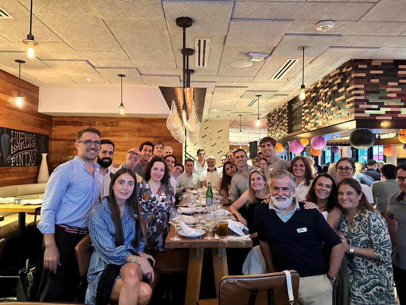 Un grupo grande de personas se reúne en un restaurante para compartir una comida y disfrutar de la compañía.