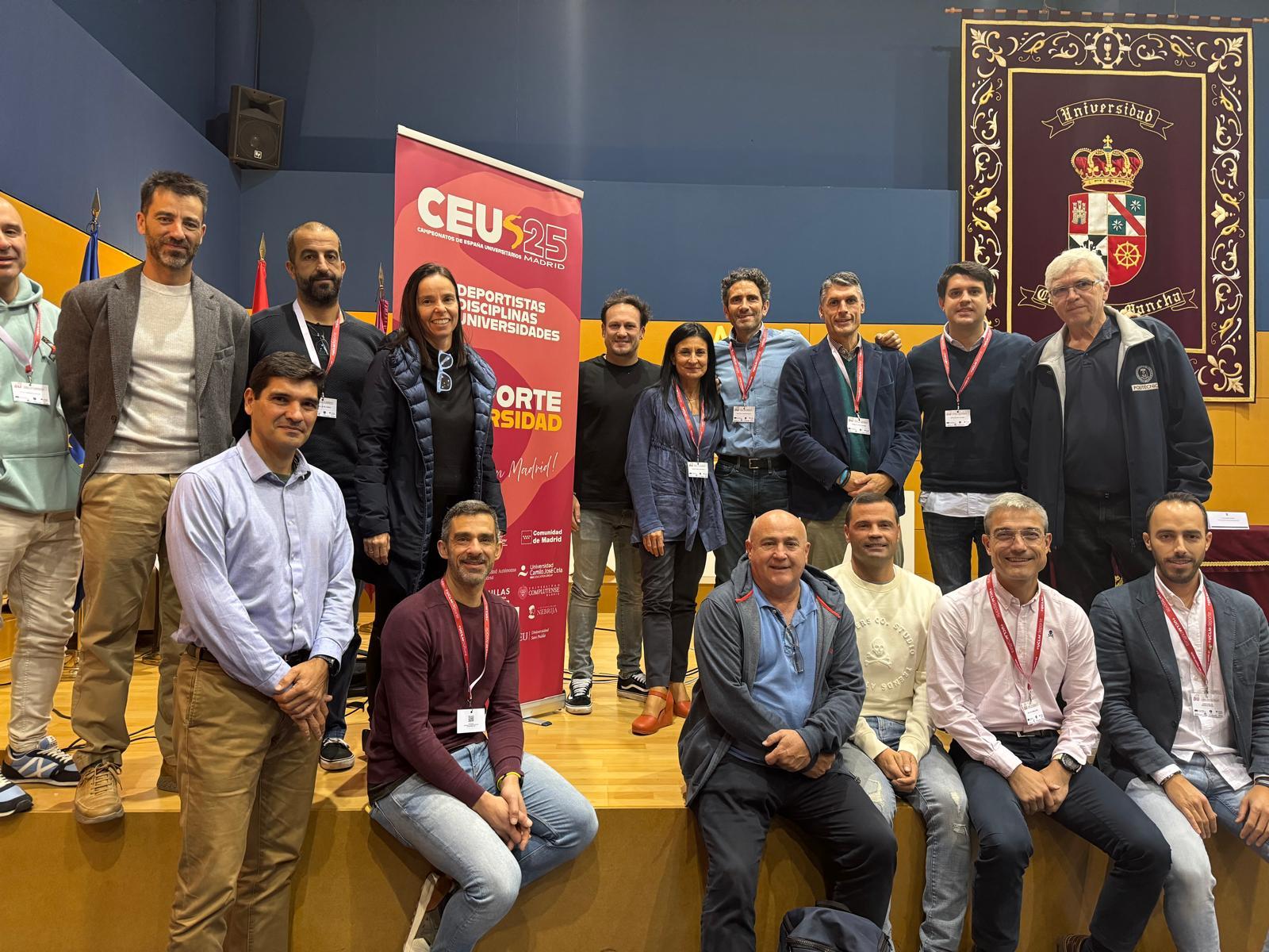 Grupo de personas posando en un evento en un salón con emblemas y una pancarta de CEU.