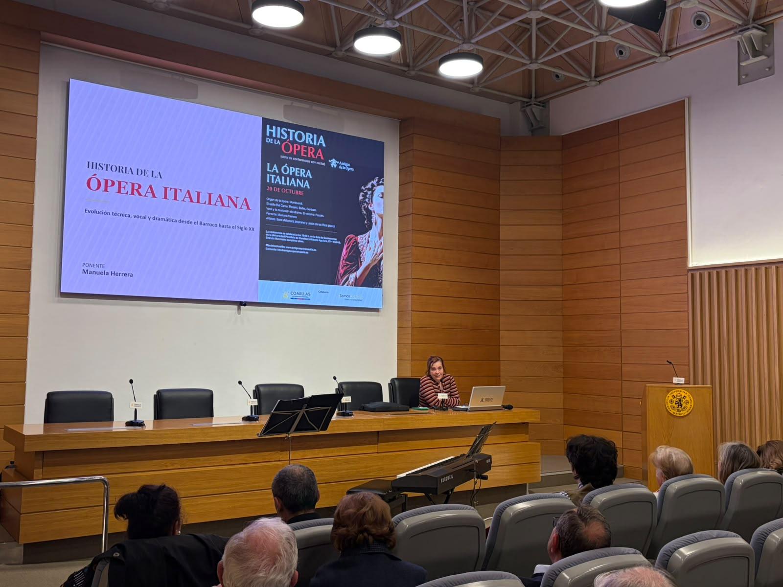 Una presentación sobre la historia de la ópera italiana en un auditorio con espectadores.