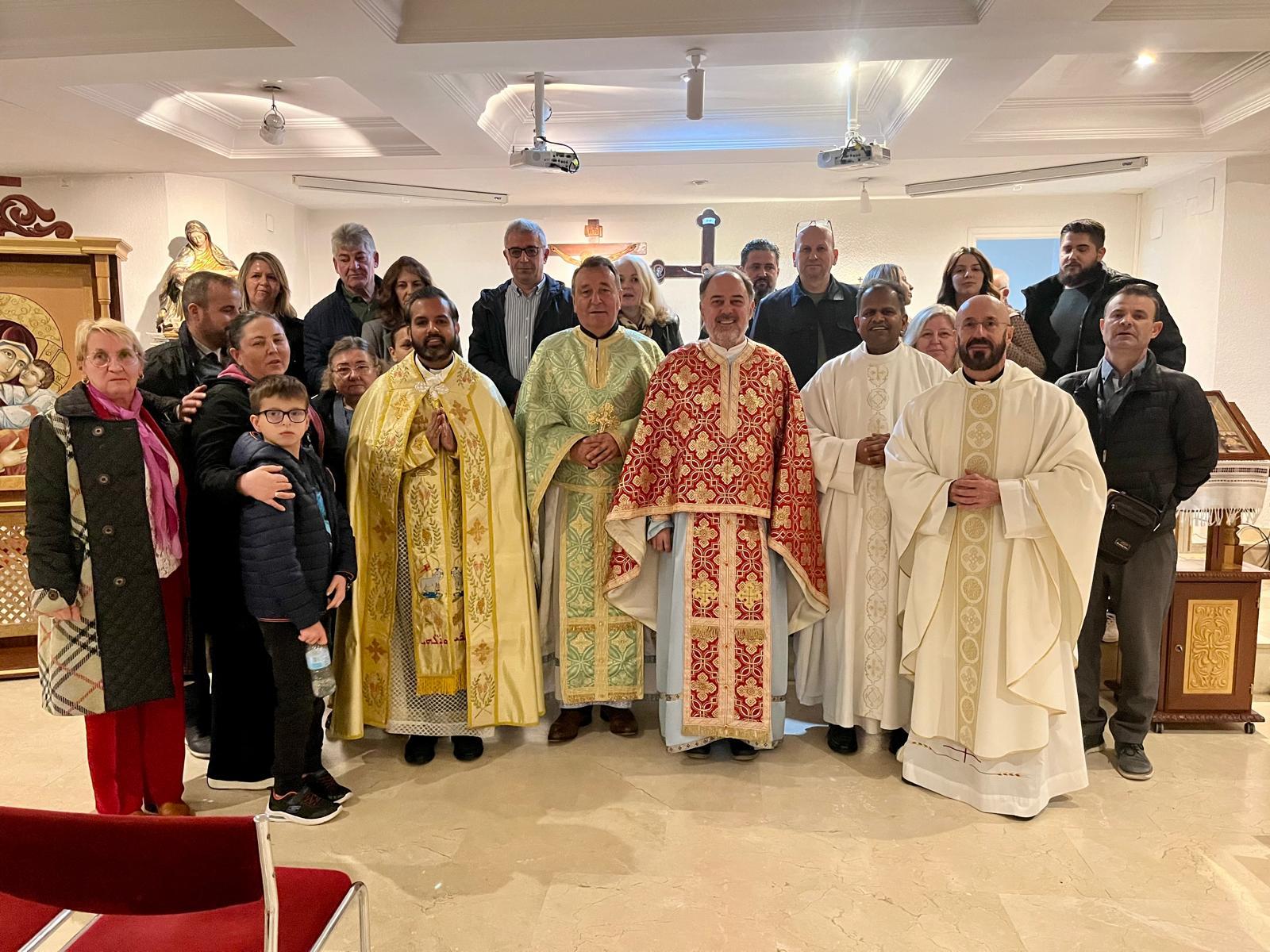 Un grupo de personas posando en una iglesia, con varios sacerdotes vestidos con ornamentos litúrgicos.