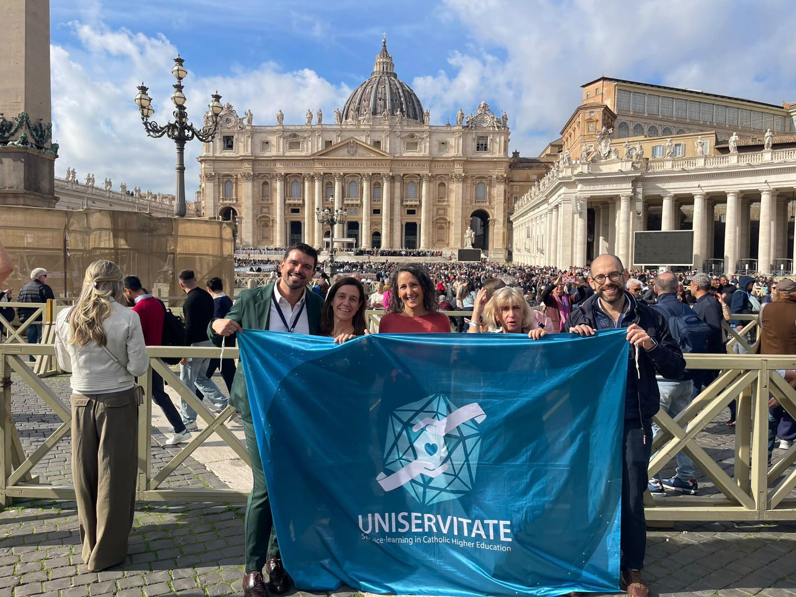 Un grupo de personas sostiene una bandera en la Plaza de San Pedro en el Vaticano.