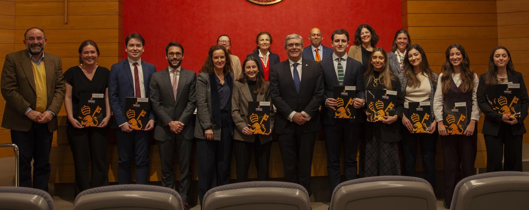 Un grupo de personas posando en un evento formal con diplomas en las manos.