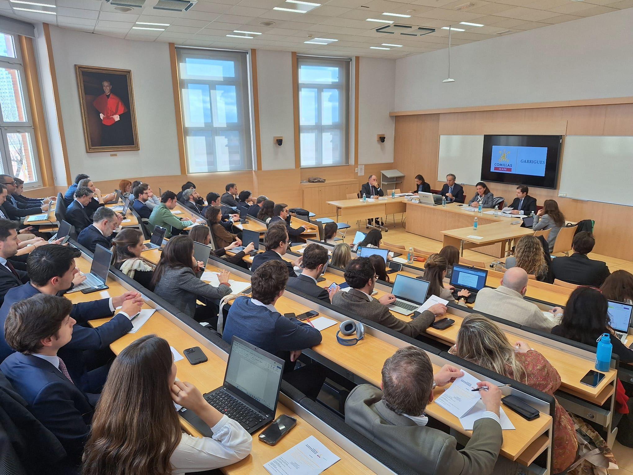 Una sala de conferencias llena de personas prestando atención a una presentación.