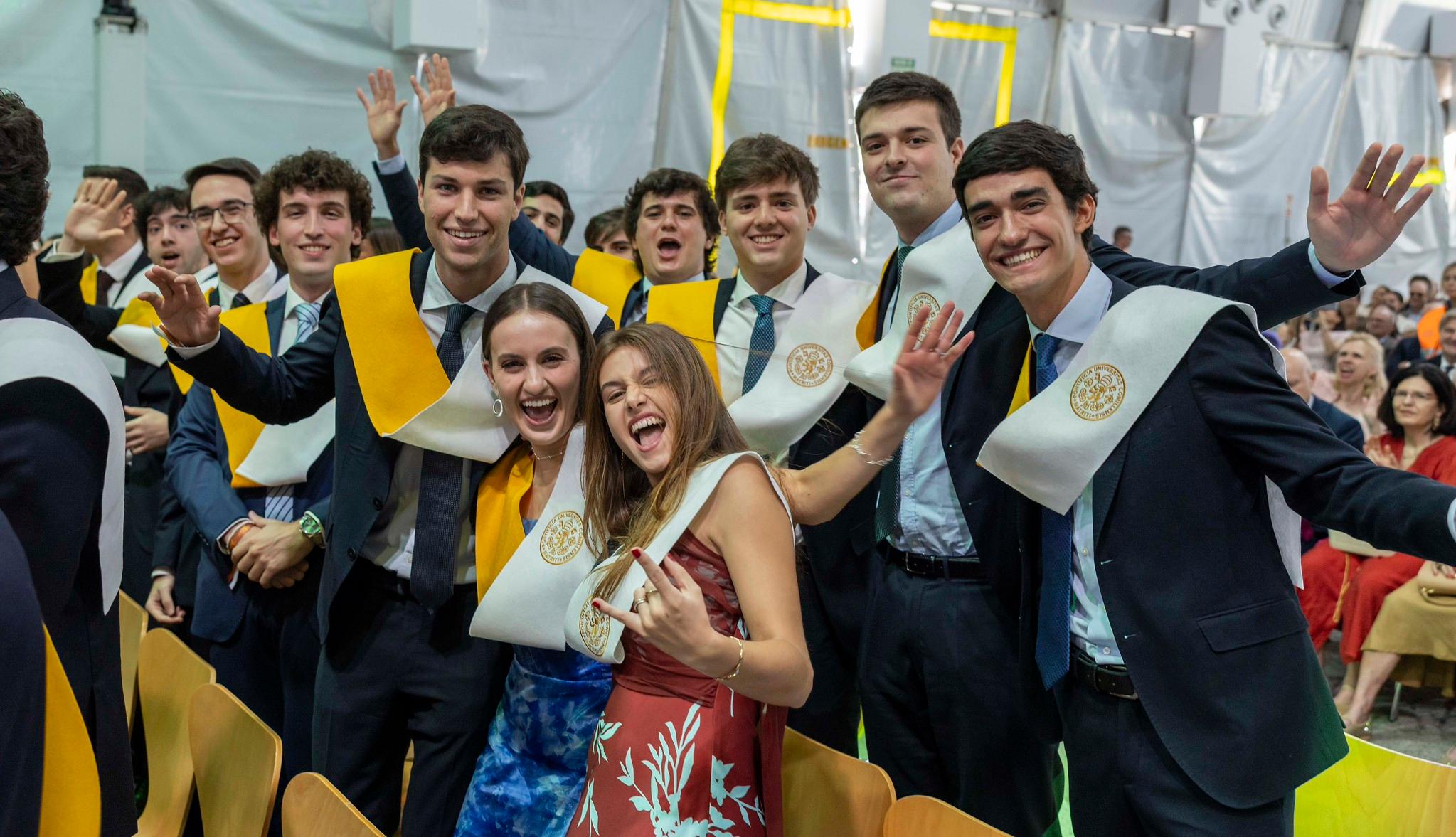Un grupo de estudiantes sonrientes celebra su graduación en una ceremonia.
