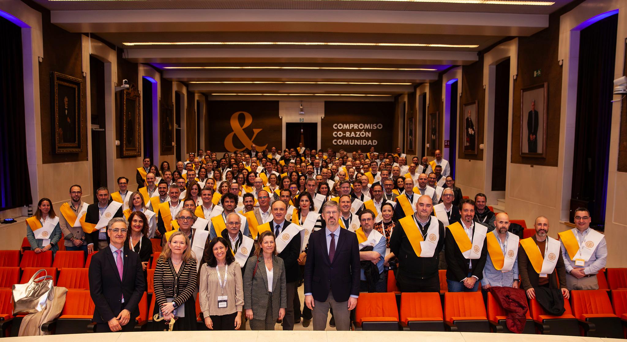 Una gran reunión de personas uniformadas con sábanas amarillas en un auditorio.