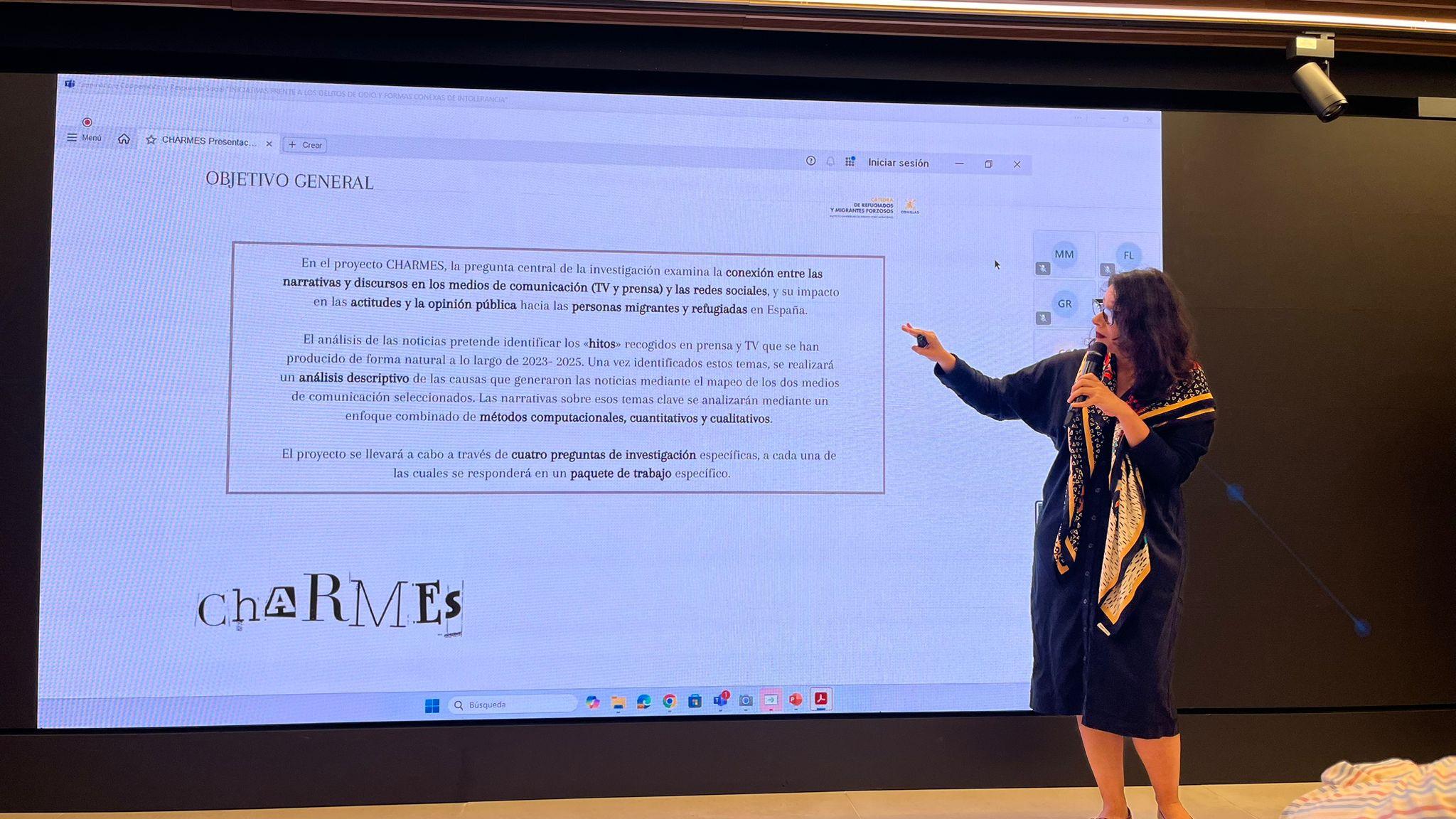 Una mujer presenta un contenido en una pantalla durante una conferencia.