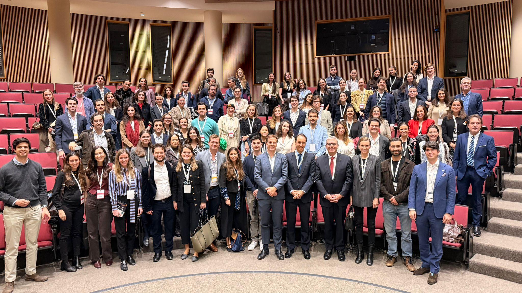 Un grupo grande de personas posando juntas en un auditorio.
