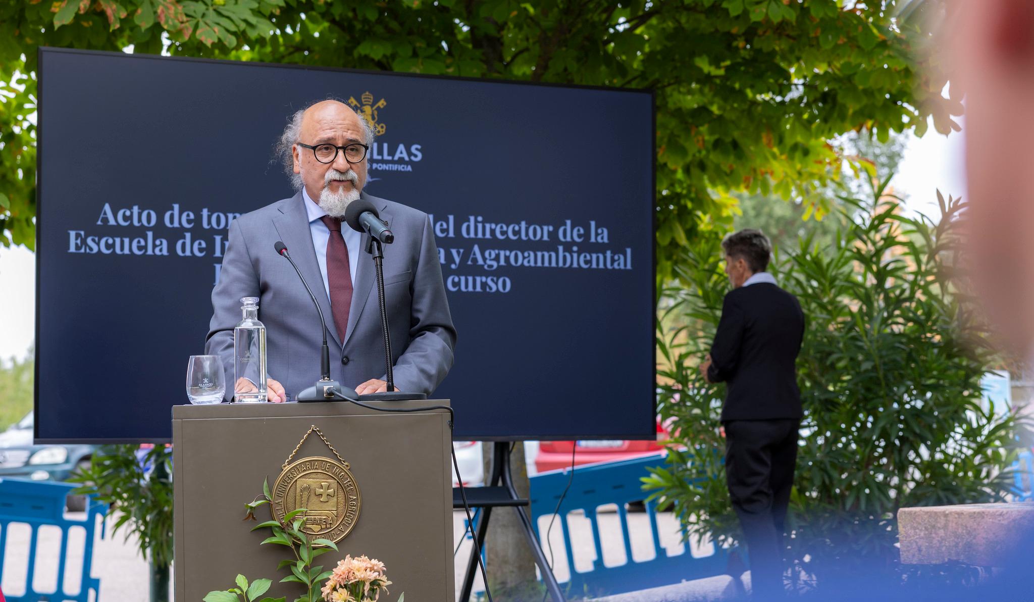 Un hombre habla en un podio durante un acto de inauguración con una pantalla detrás que muestra información sobre la Escuela de Ingeniería y Agroambiental.