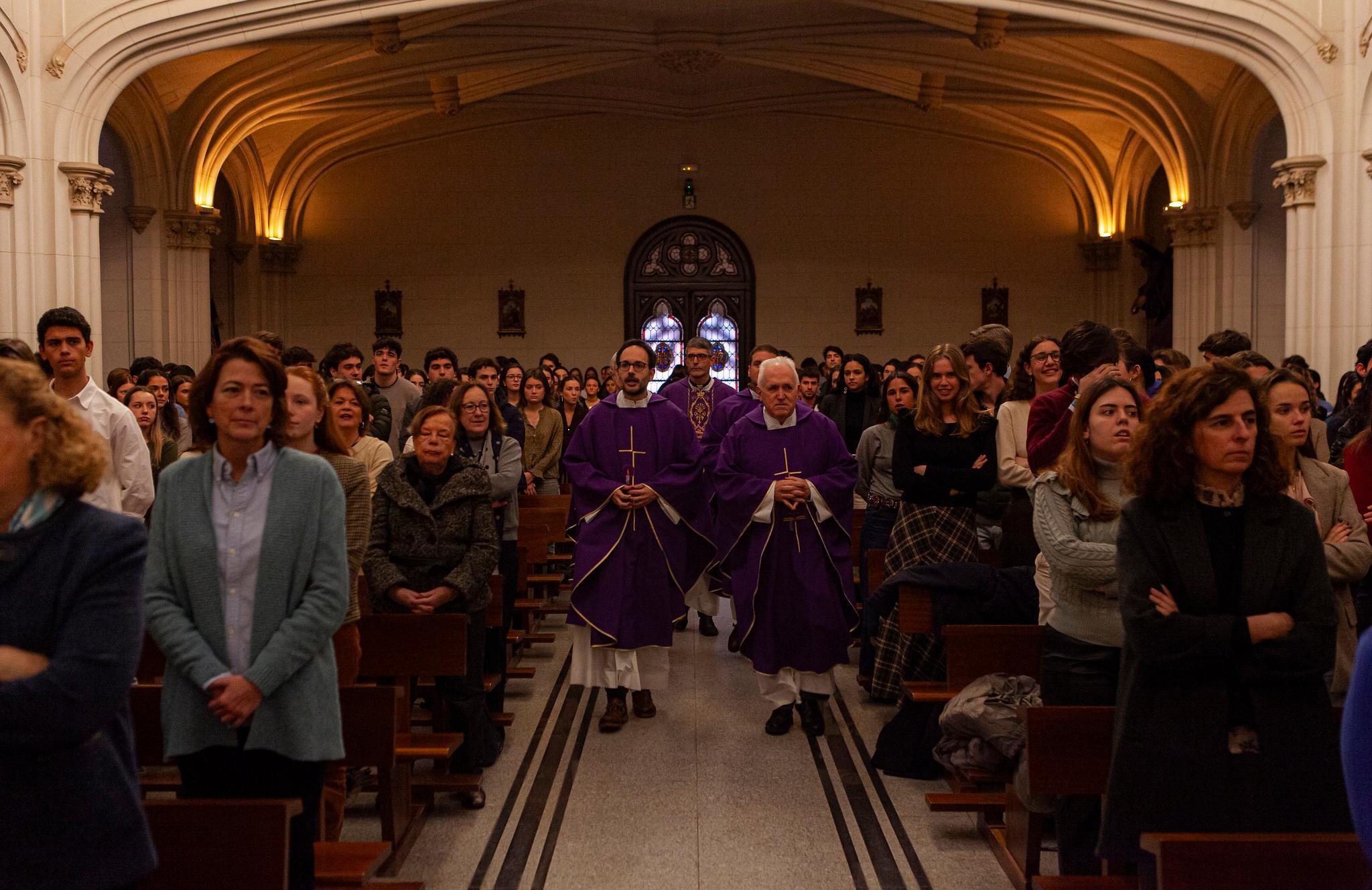 Una ceremonia religiosa con personas asistiendo en un lugar con iluminación tenue.