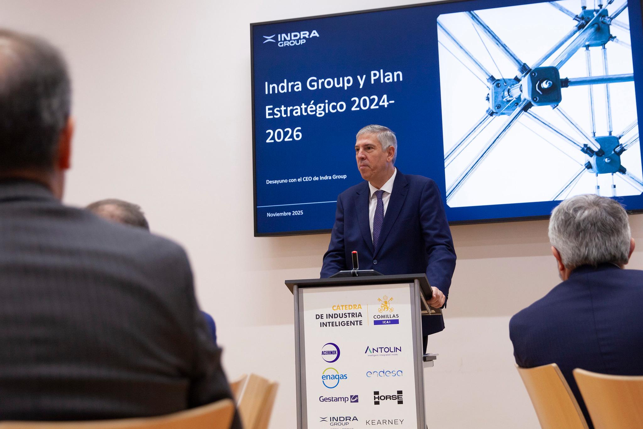 Un hombre presenta el Plan Estratégico 2024-2026 de Indra Group en un evento empresarial.