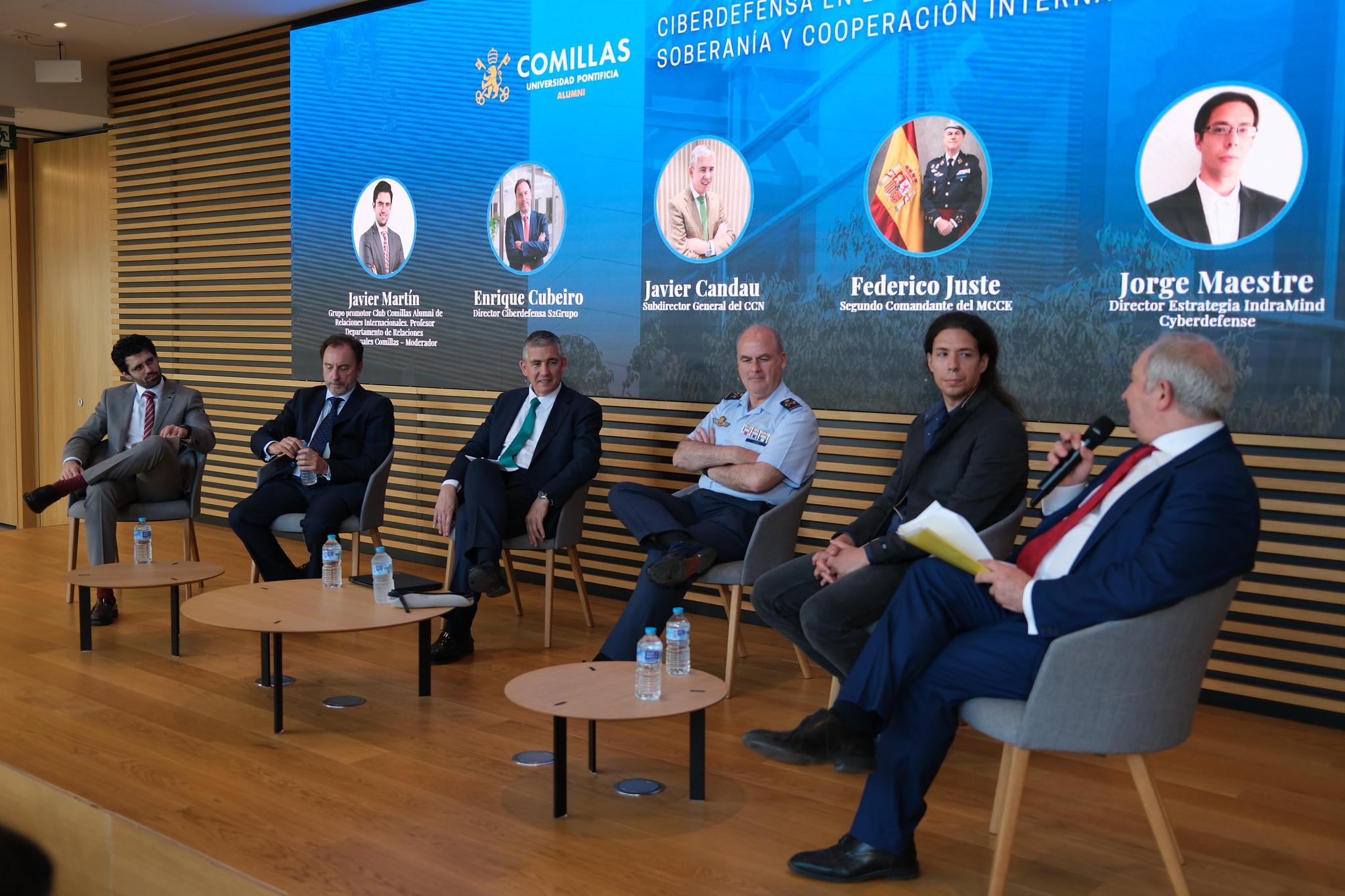 Fotografía de un panel de expertos discutiendo sobre ciberdefensa en un evento en la Universidad de Comillas.