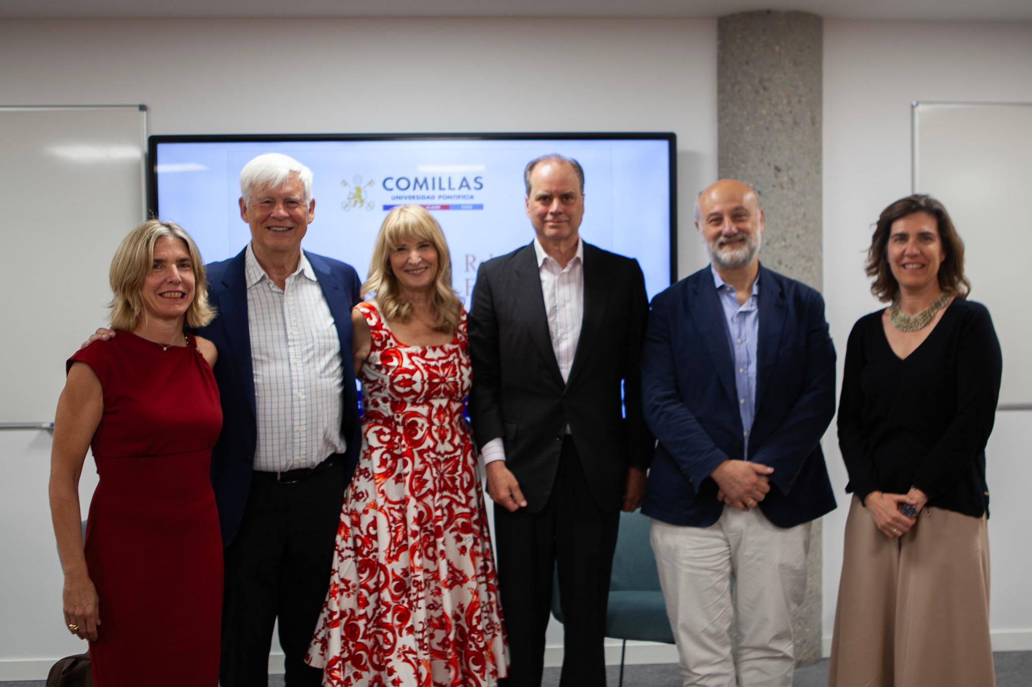 Un grupo de seis personas sonrientes posando para una fotografía en el interior de un edificio.