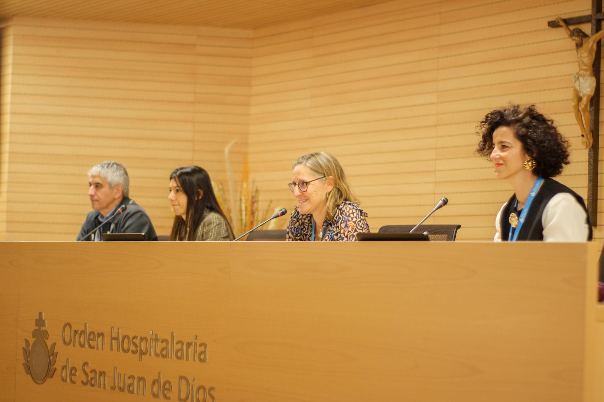 Cuatro personas sentadas frente a un atril en un evento en la Orden Hospitalaria de San Juan de Dios.