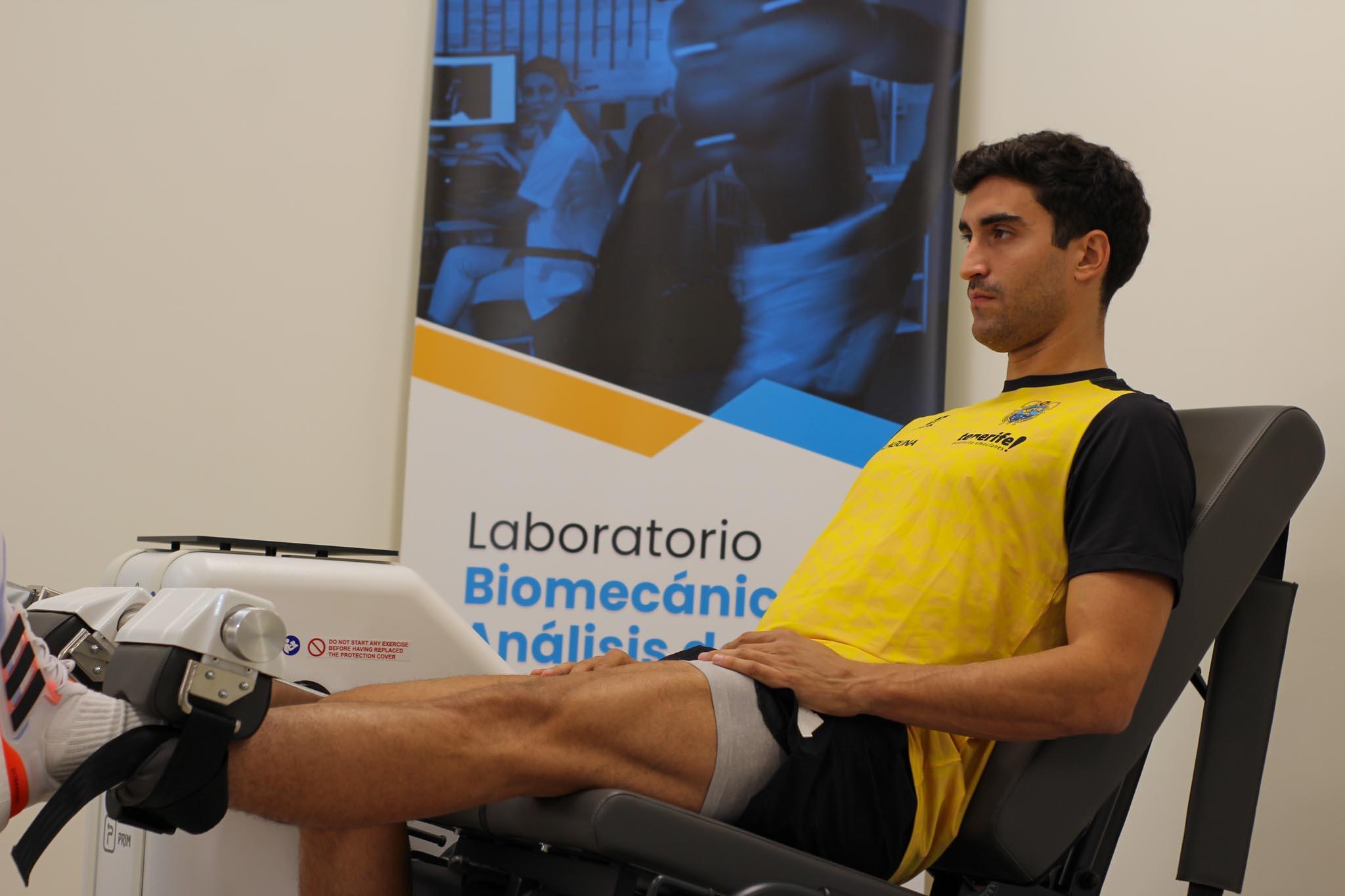 Un hombre realiza una prueba de extensión de pierna en una máquina en un laboratorio de biomecánica.