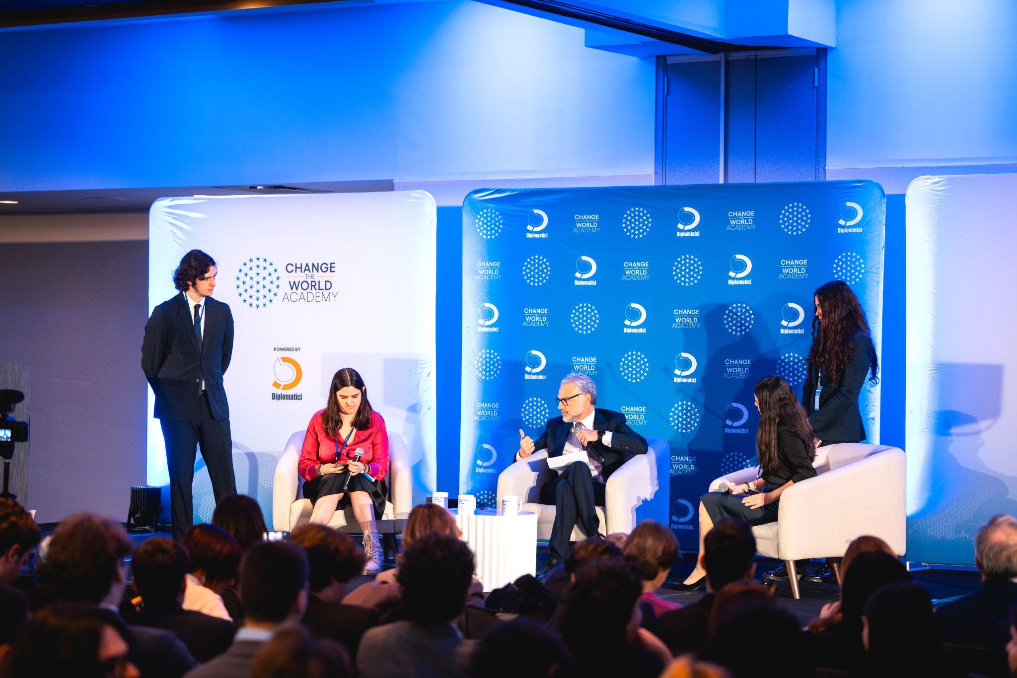 Una mesa redonda con varios participantes discutiendo en un evento sobre cambio mundial.